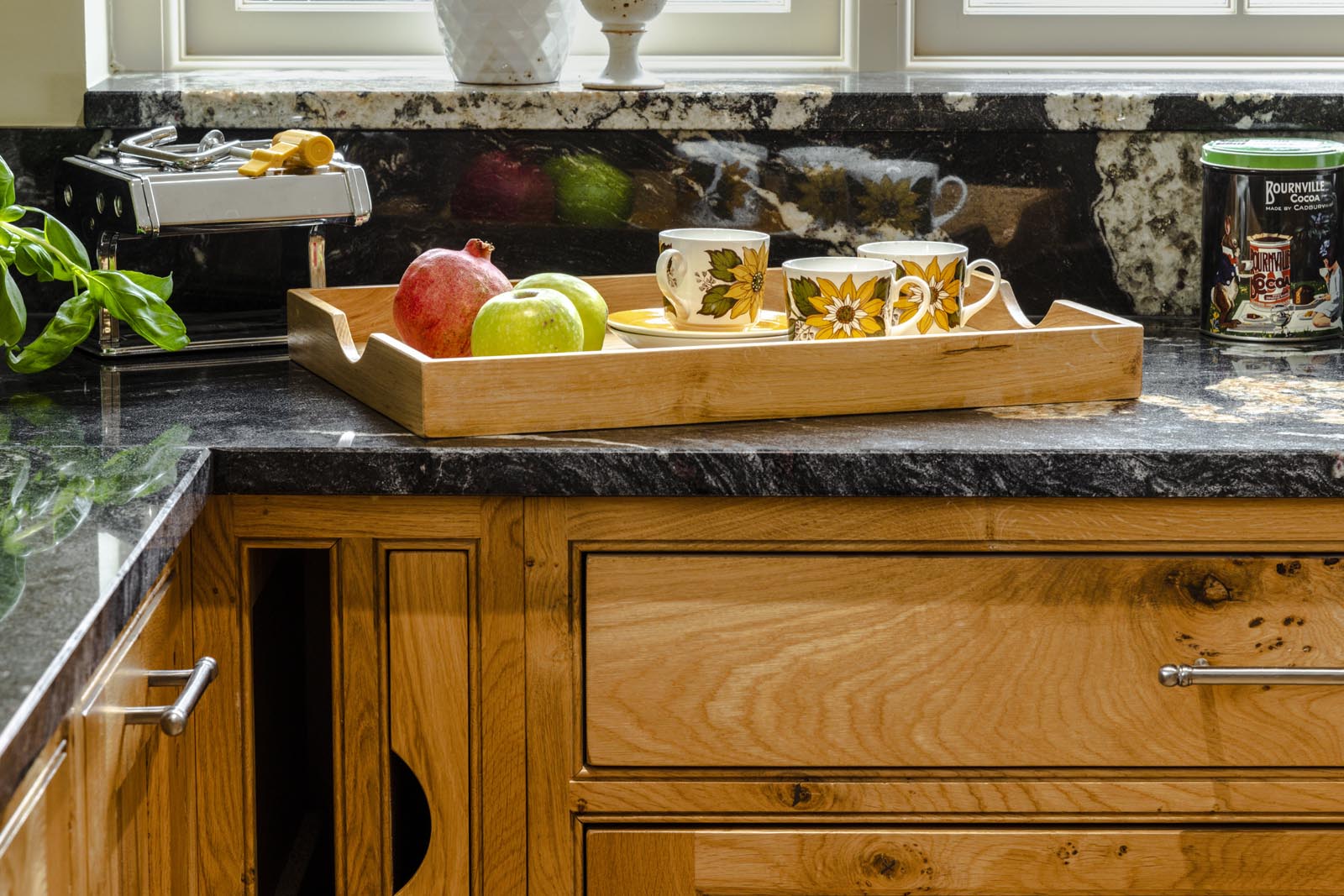 Zoomed in feature of an oak kitchen shows hidden cutting-boards and stylish drawers